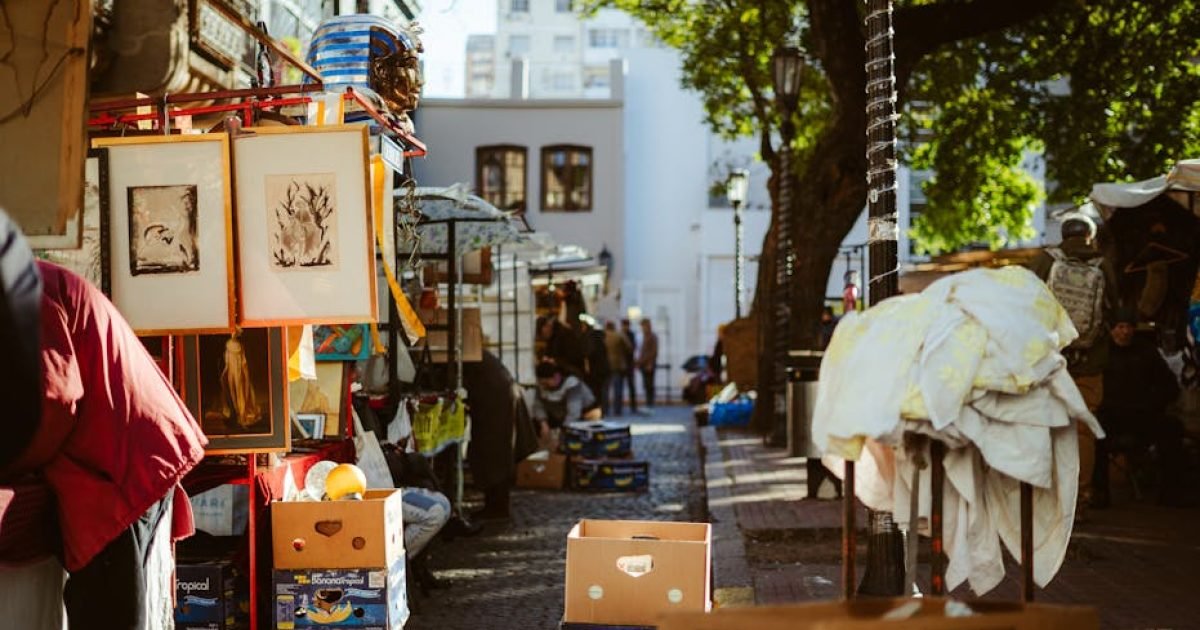 Um movimentado mercado de rua ao ar livre em Buenos Aires com arte e produtos em exposição.